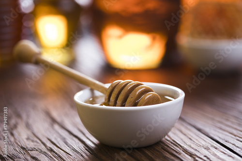 Honey in jar with honey dipper on wooden background 