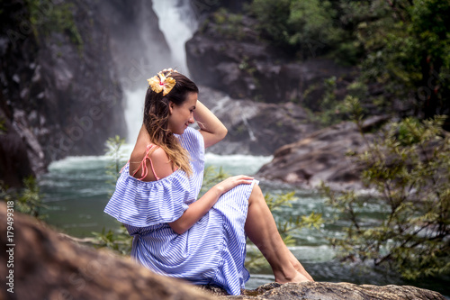 Girl sitting by the waterfall