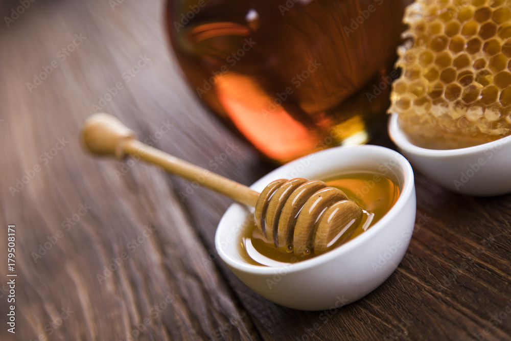 Honey in jar with honey dipper on wooden background Honey in jar with honey dipper on wooden background
