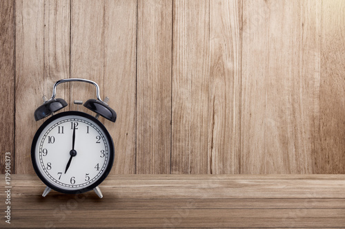 black alarmclock on wood floor and wall texture background with free copyspace for your ideas text