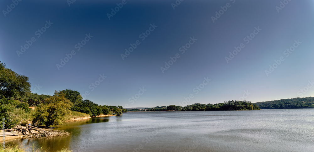 Panoramic view of a lake formed by a marsh called Cecebre in Galicia (Spain) with vegetated banks, mainly trees