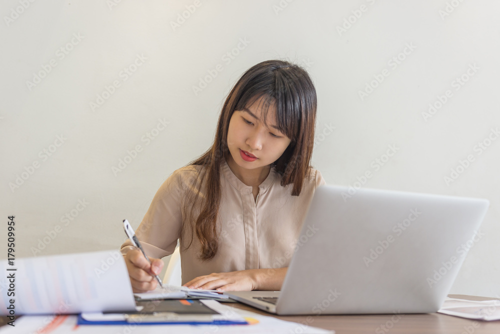Close-up of businesswoman writing notes in office Close-up of businesswoman writing notes in office