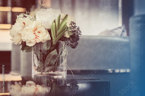 BEAUTIFUL WHITE AND YELLOW FRESH FLOWER IN SHINY GLASS VAES ON SIDE TABLE INTERIOR CONCEPT photo