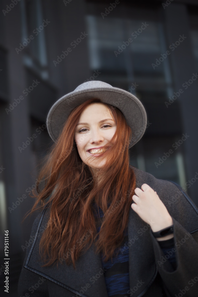 Outdoor portrait. Young stylish beautiful woman in hat while walking in the big city streets. Outdoor portrait. Young stylish beautiful woman in hat while walking in the big city streets.