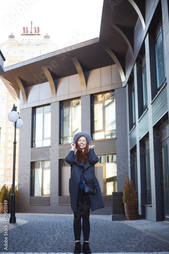 Outdoor portrait. Young stylish beautiful woman in hat while walking in the big city streets. © My Ocean studio