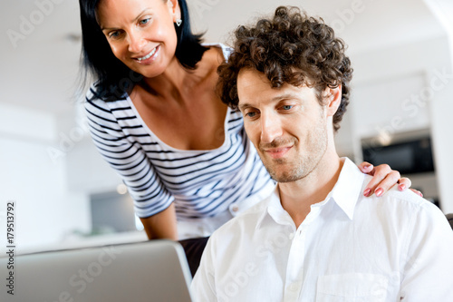 Couple at home using laptop
