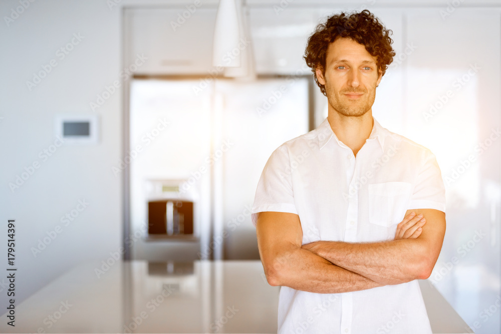 Portrait of a smart young man standing in kitchen