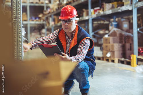Happy businessman with clipboard at warehouse