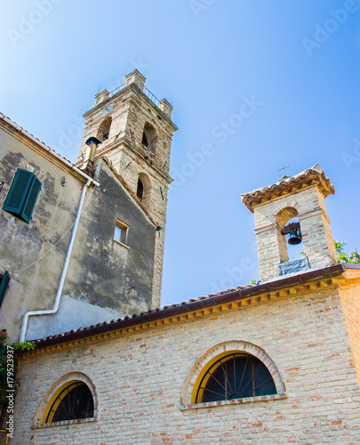 Church's steeple on clear blue sky in Saludecio, a little medieval town in the Montefeltro, in the Emilia Romagna region, between Rimini and Urbino photo