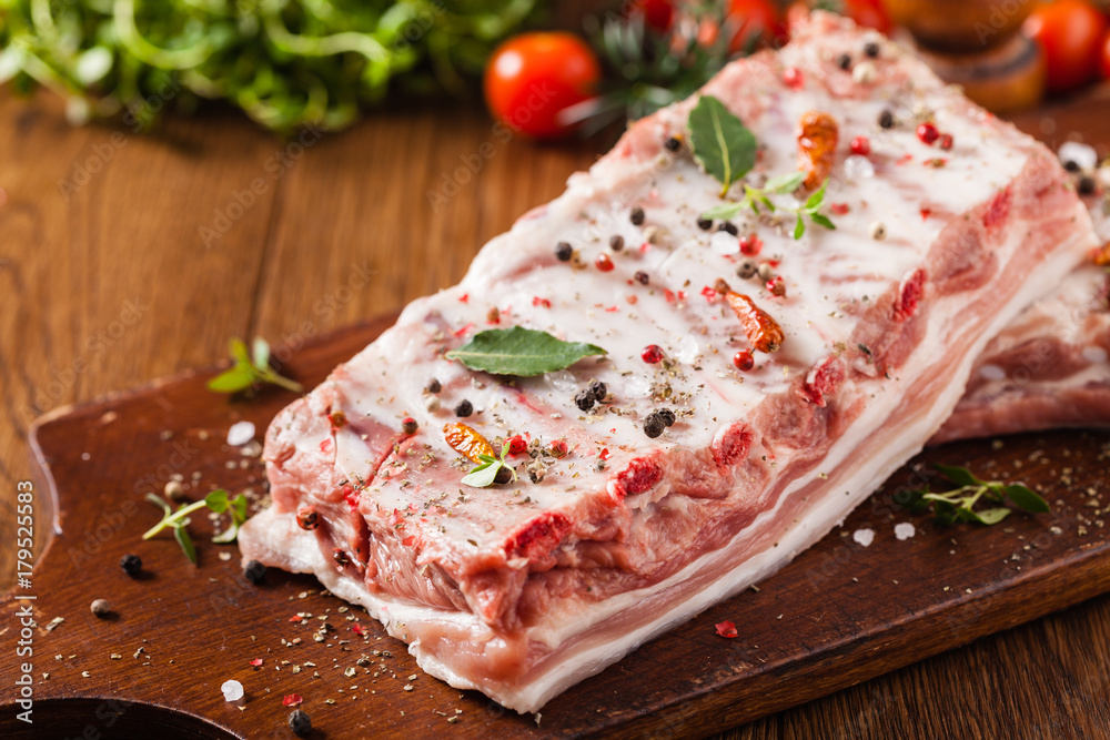 Raw pork ribs, on a plate sprinkled with spices. Raw pork ribs, on a plate sprinkled with spices.