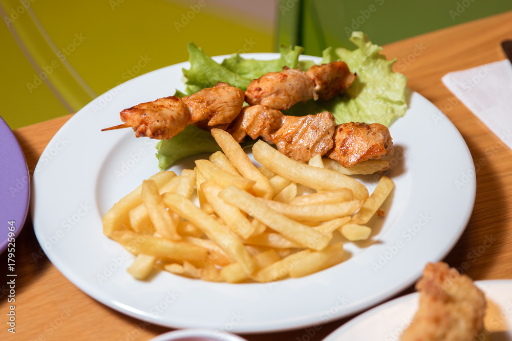 Grilled chicken on bamboo skewers, close up view. Chicken kebab with cartilage fry in the plate . Grilled chicken on bamboo skewers, close up view. Chicken kebab with cartilage fry in the plate .
