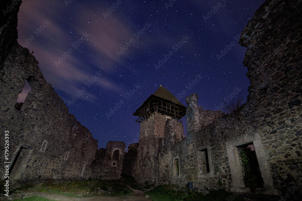 Ruins of Nevitsky Castle near Uzhgorod, Ukraine with a lot of shiny stars on the dark blue sky