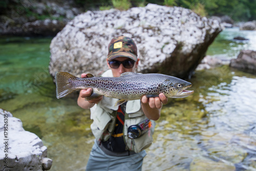 Fly fisherman with brown trout