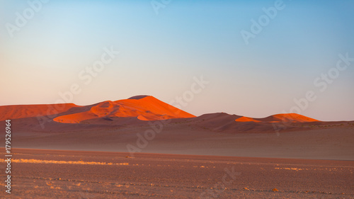 Sossusvlei Namibia, travel destination in Africa. Sand Dunes and clay salt pan with acacia trees, Namib Naukluft National Park, Namib desert.