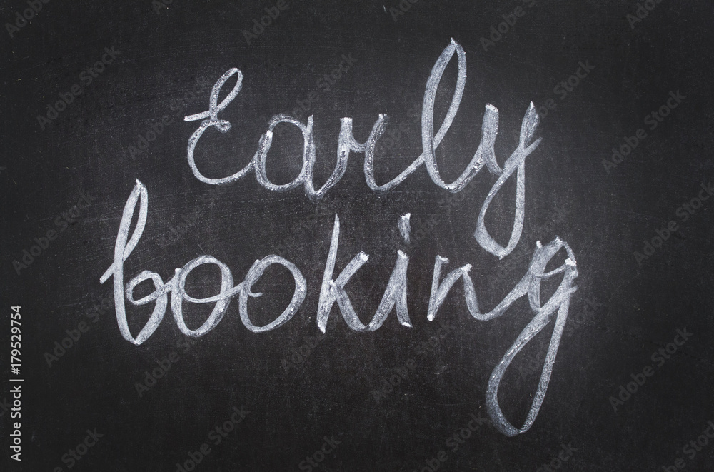 Fototapeta premium Text Early Booking handwritten with white chalk on a blackboard. banner for sale offer.