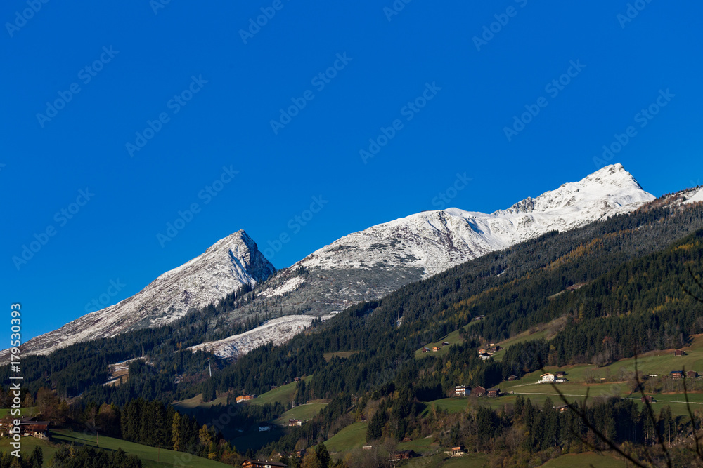 sunny mountain panorama in late autumn with first snow and bue sky