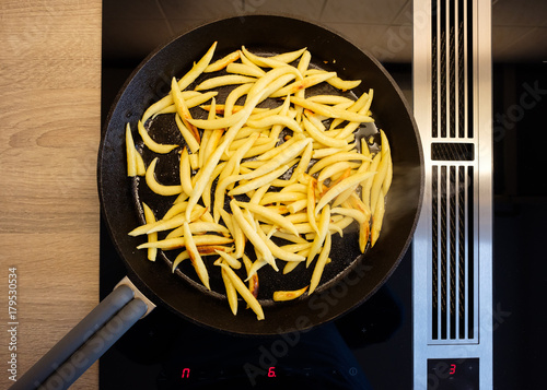 Schupfnudeln braten in Pfanne aus Gußeisen auf Induktionsherd photo