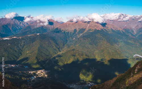 Beautiful top view on Caucasus mountains in autumn with magnificent mountain ridges and clouds casting shadows on its slopes. Krasnaya Polyana  Sochi  Russia