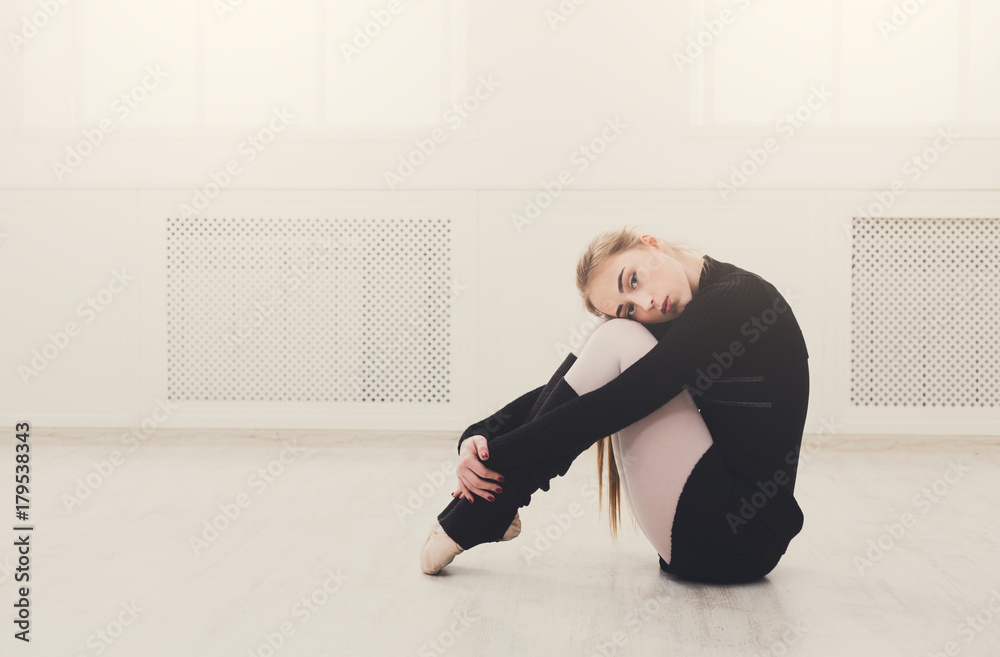 Classical ballet dancer stretching in white training class Classical ballet dancer stretching in white training class