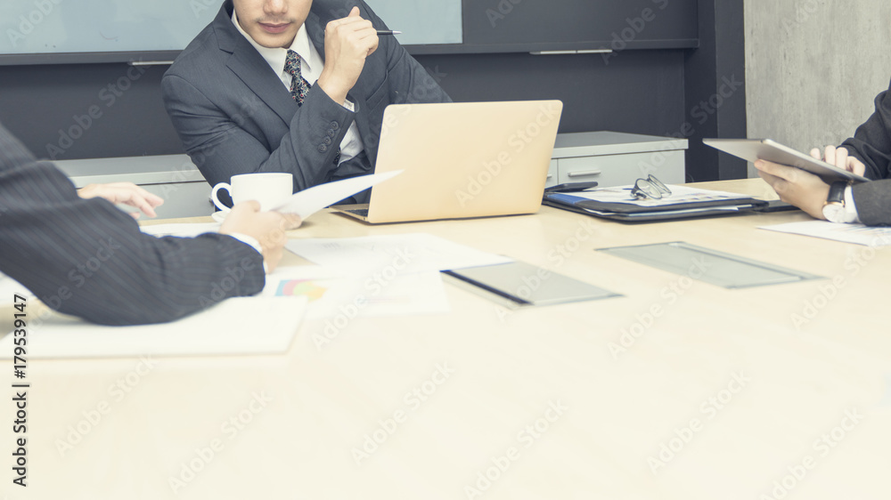 Young Asian business man manager discuss about his work with coworkers while woman secretary show work progress to him in mordern office. Young Asian business man manager discuss about his work with coworkers while woman secretary show work progress to him in mordern office.