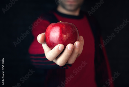 Man hold red apple.
