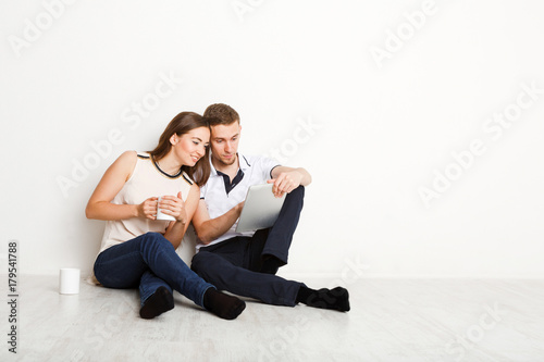 Young couple web surfing on laptop