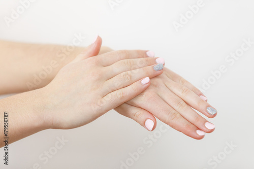 Woman taking care of her dry hands applying cream.