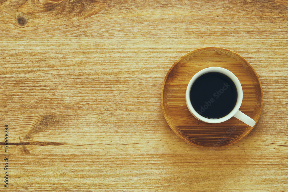 Obraz premium top view image of cup of coffee on wooden table.