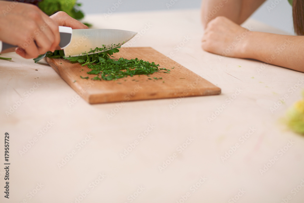Close-up of human hands cooking vegetables salad in kitchen. Healthy meal and vegetarian concept Close-up of human hands cooking vegetables salad in kitchen. Healthy meal and vegetarian concept