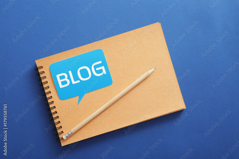 Notebook with word BLOG on color background