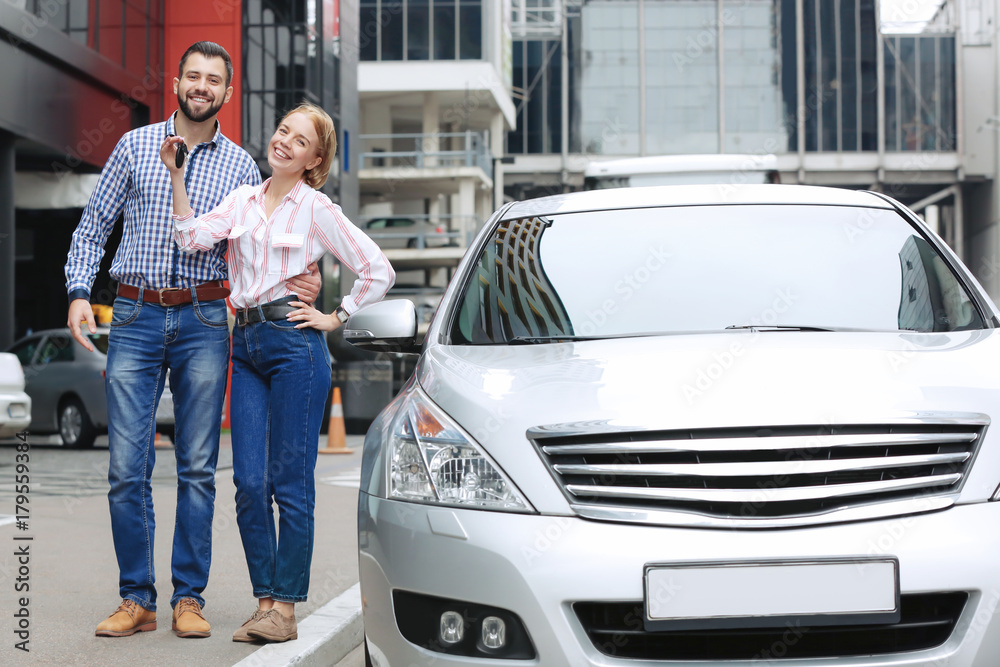 Young couple standing near car outdoors Young couple standing near car outdoors