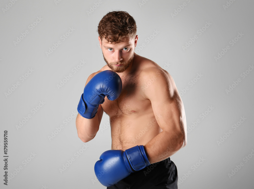 Male boxer on light background