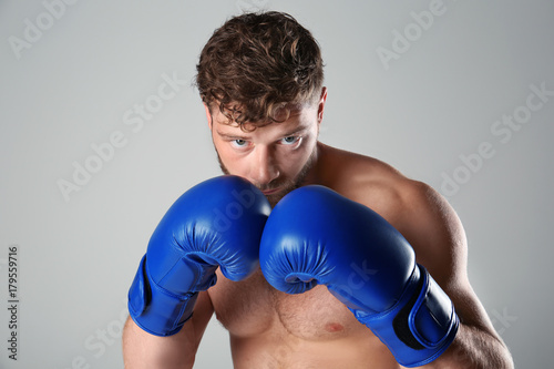 Male boxer on light background