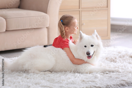 Fototapeta Naklejka Na Ścianę i Meble -  Cute little girl with dog at home