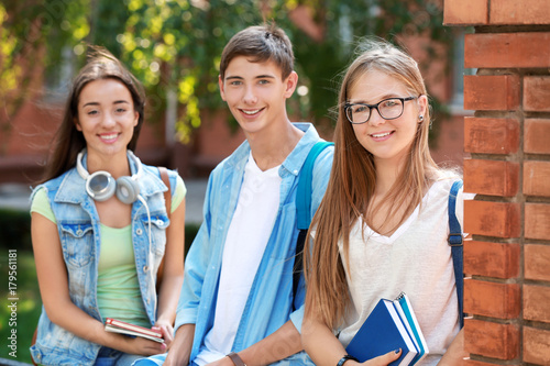 Happy students with books o...