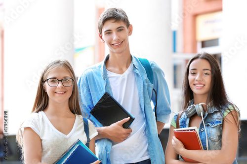 Happy students with books o...
