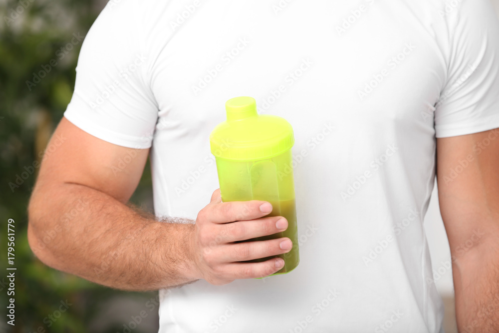 Young man holding bottle with protein shake, closeup Young man holding bottle with protein shake, closeup