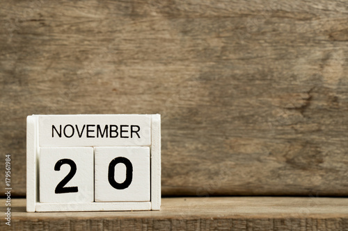 White block calendar present date 20 and month November on wood background