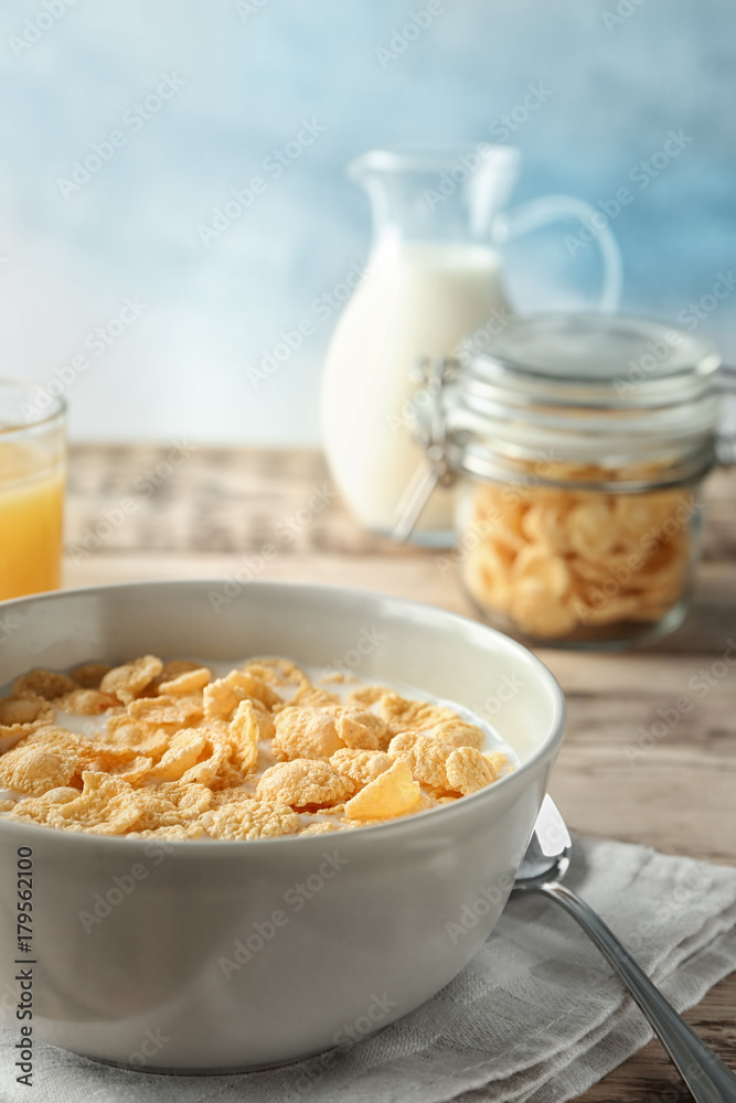 Dish with cornflakes and milk on table Dish with cornflakes and milk on table