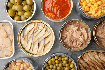 Open tin cans with different food on table