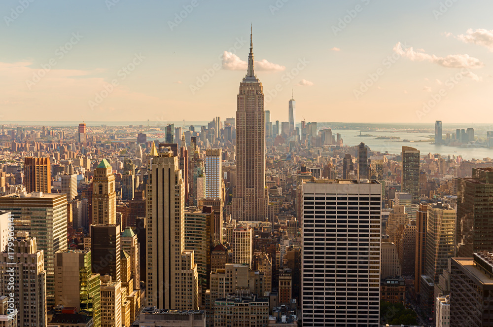 Obraz premium Manhattan Midtown Skyline z oświetlonymi wieżowcami o zachodzie słońca. NYC, USA