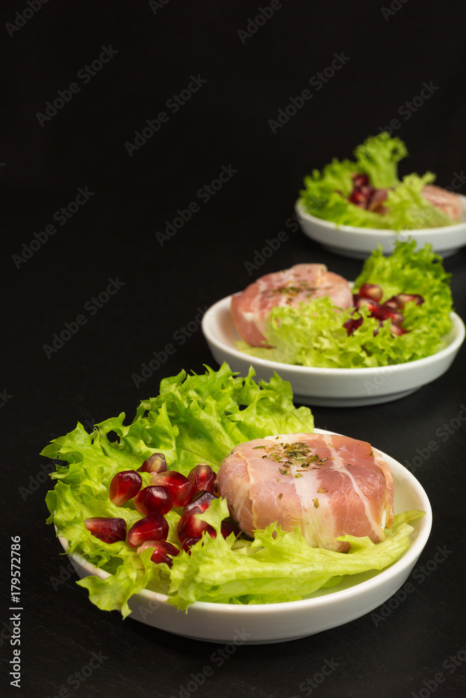 goat cheese with bacon on a frisee lettuce leaf with pomegranate as garnishing goat cheese with bacon on a frisee lettuce leaf with pomegranate as garnishing