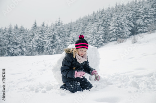 little child building a snowman