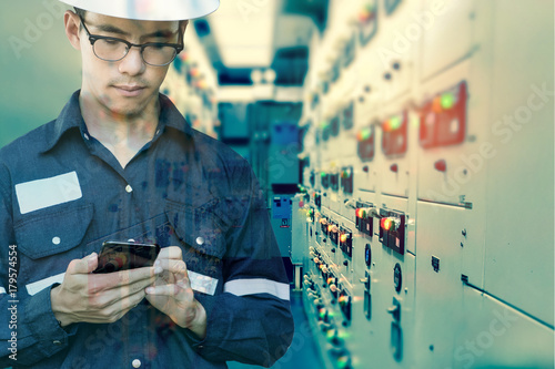 Double exposure of  Engineer or Technician man using smart phone for control electric in switch gear electrical oil and gas platform or plant industrial for monitor process, business industry concept