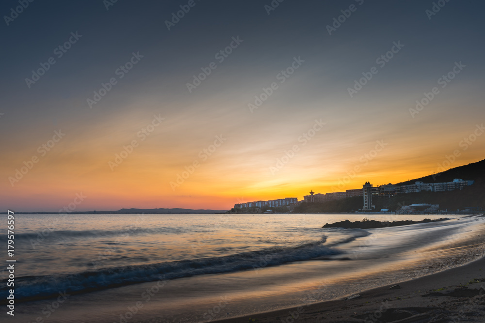 Colorful sunset over sea bay beach in Bulgaria with Nessebar city in cinematic look.