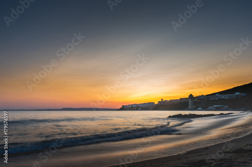 Colorful sunset over sea bay beach in Bulgaria with Nessebar city in cinematic look.