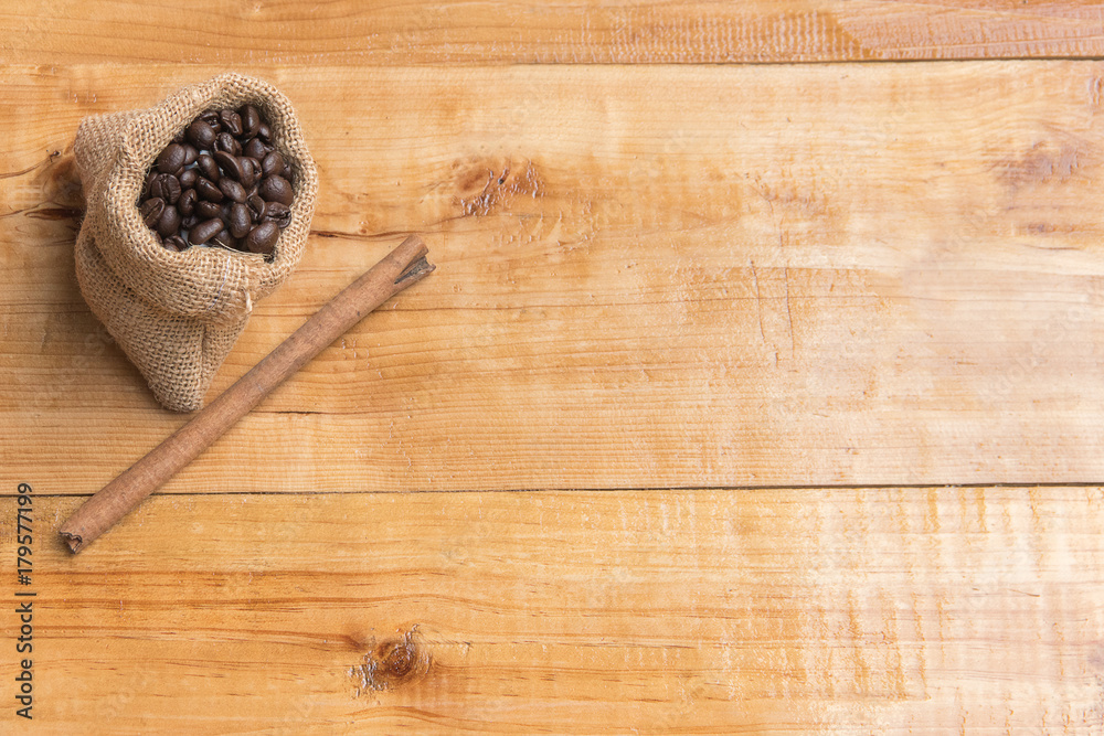 Coffee bean on small sack of brown and cinnamon over wooden table board, copy space, presentation product, top view Coffee bean on small sack of brown and cinnamon over wooden table board, copy space, presentation product, top view