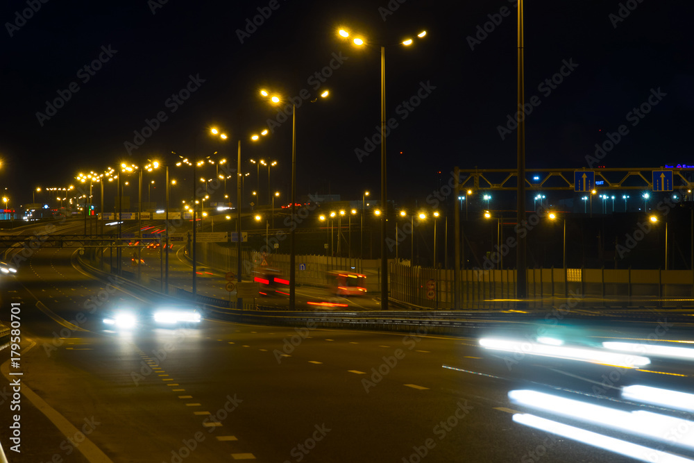 Highway traffic cars at night blured. Cars moving on road on bridge evening blurry.