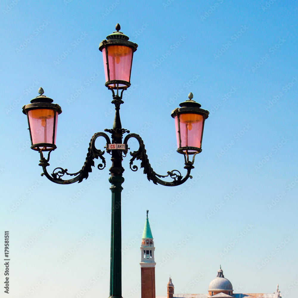 August, 18, 2012, Venice, Italy: traditional Venetian pink lantern of three lamps on background of a blue sky