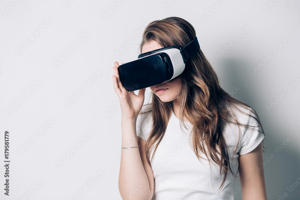 Young woman using a virtual reality headset on a white background Young woman using a virtual reality headset on a white background